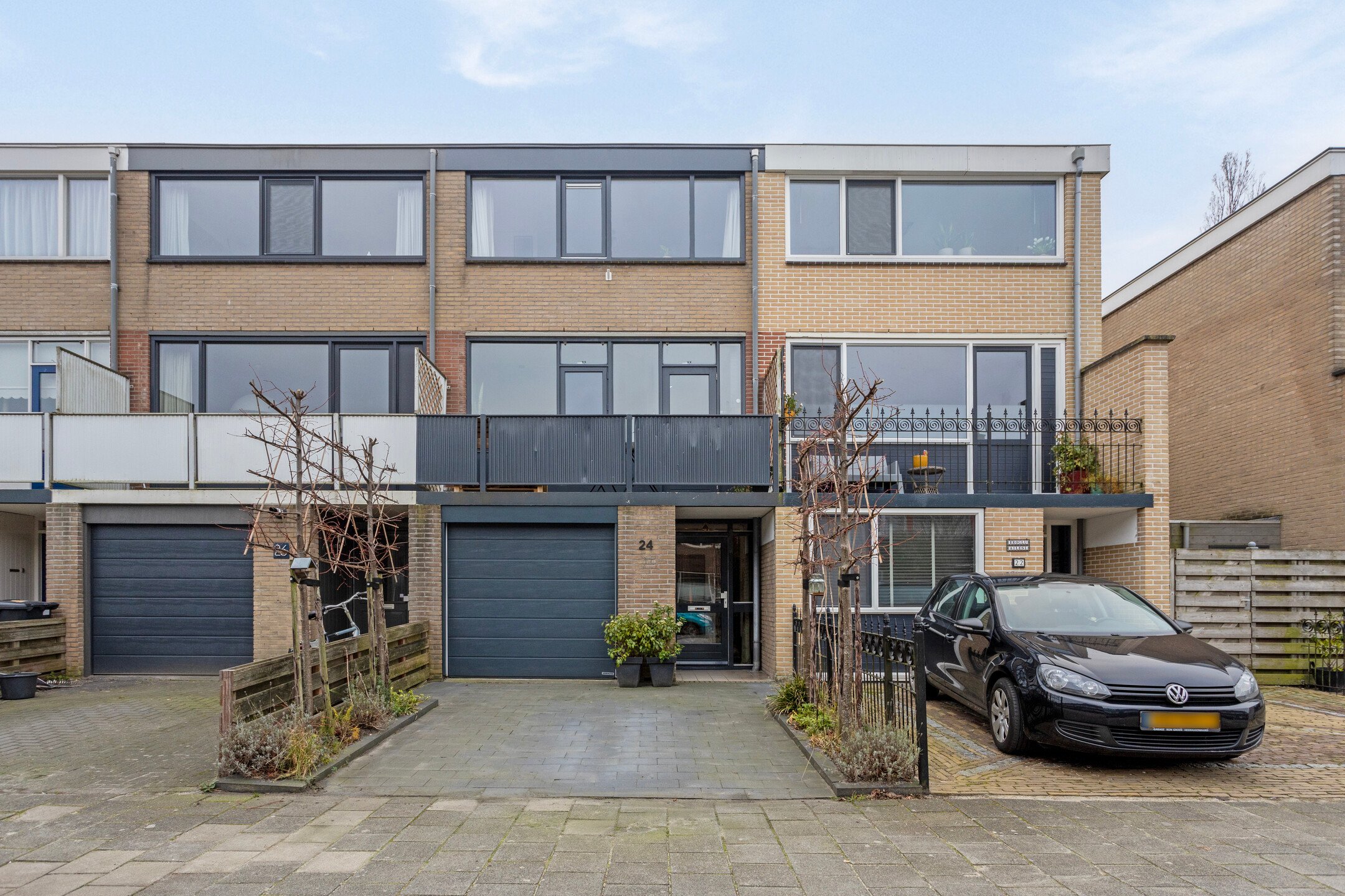 Huizen van drie verdiepingen met een garage beneden in de woning met een pad ervoor.